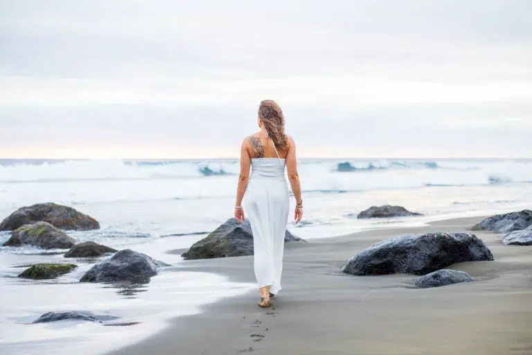 Femme en robe blanche marchant sur une plage de La Réunion
