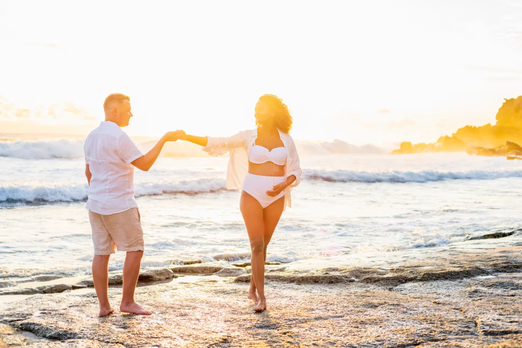 Couple attendant un enfant pendant une séance grossesse au coucher du soleil