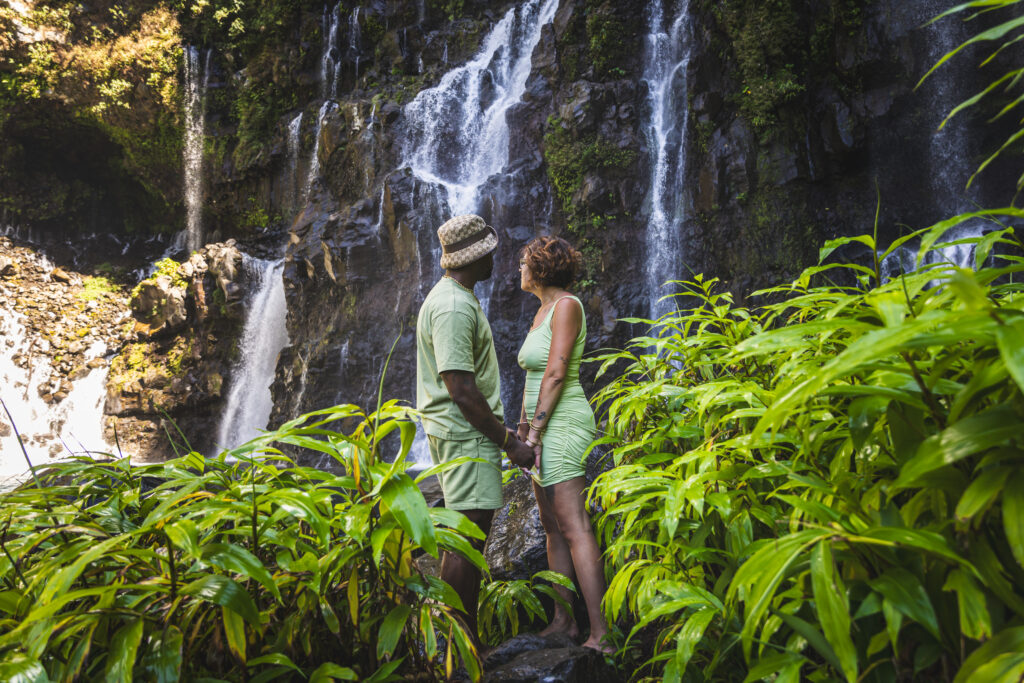 Couple photographié lors d’un shooting photo à La Réunion, devant une cascade