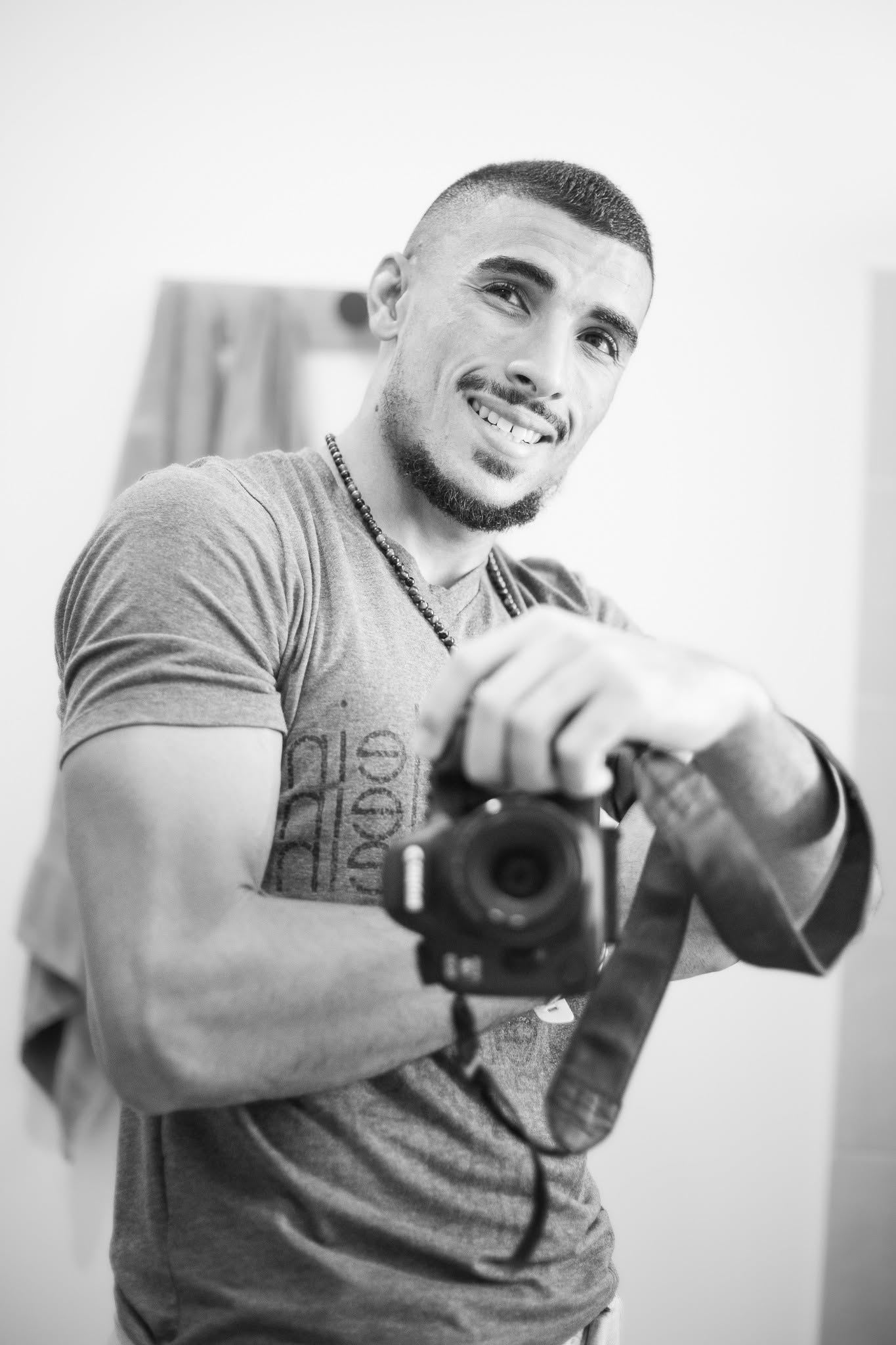 Portrait noir et blanc de Loïc Esparon, photographe 974, avec son appareil